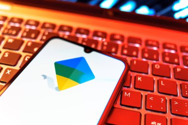Prag, Çek Cumhuriyeti - 08 19 2025: Google Family Link logosunu gösteren klavyenin üzerinde duran cep telefonunun yakından görüntüsü. Google Family Link ebeveyn denetimi ve çocuk hesabı yönetimi için bir platformdur.