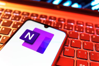 Prag, Çek Cumhuriyeti - 08 19 2025: Klavyede duran ve Microsoft OneNote logosunu gösteren bir cep telefonunun yakından görüntüsü. Microsoft OneNote not almak ve düzenlemek için bir platformdur.
