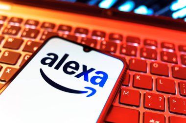 Prag, Çek Cumhuriyeti - 08 19 2025: Klavyenin üzerinde Alexa logosunu gösteren cep telefonunun yakın çekim görüntüsü. Alexa akıllı aygıtlar ve servisler için ses asistanıdır.