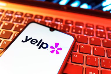 Prag, Çek Cumhuriyeti - 08 19 2025: Klavyede duran ve Yelp logosunu gösteren bir cep telefonunun yakından görüntüsü. Yelp yerel işletmeleri bulmak ve incelemek için bir platformdur.