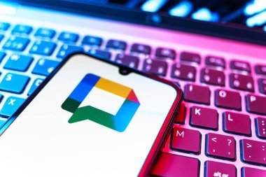 Prag, Çek Cumhuriyeti - 08 19 2025: Google Chat logosunu gösteren klavyenin üzerinde duran cep telefonunun yakından görüntüsü. Google Chat mesajlaşma ve takım işbirliği için bir platformdur.