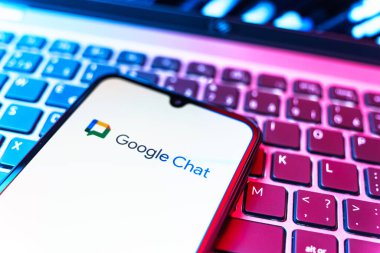 Prag, Çek Cumhuriyeti - 08 19 2025: Google Chat logosunu gösteren klavyenin üzerinde duran cep telefonunun yakından görüntüsü. Google Chat mesajlaşma ve takım işbirliği için bir platformdur.
