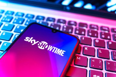 Prag, Çek Cumhuriyeti - 08 19 2025: SkyShowtime logosunu gösteren klavyenin üzerinde duran cep telefonunun yakından görüntüsü. SkyShowtime, sinema ve televizyon dizileri için bir yayın platformudur..