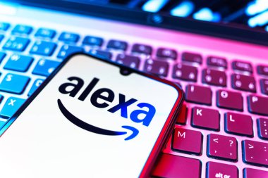Prag, Çek Cumhuriyeti - 08 19 2025: Klavyenin üzerinde Alexa logosunu gösteren cep telefonunun yakın çekim görüntüsü. Alexa akıllı aygıtlar ve servisler için ses asistanıdır.