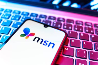 Prag, Çek Cumhuriyeti - 08 19 2025: MSN logosunu gösteren klavyenin üzerinde duran cep telefonunun yakından görüntüsü. MSN haber, e-posta ve çevrimiçi hizmetler için bir platformdur.