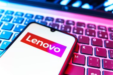 Prag, Çek Cumhuriyeti - 08 19 2025: Klavyede duran ve Lenovo logosunu gösteren bir cep telefonunun yakından görüntüsü. Lenovo bilgisayar ve elektronik üreten bir teknoloji şirketidir..