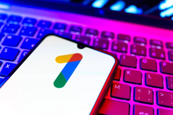 Prag, Çek Cumhuriyeti - 08 19 2025: Bir klavyenin üzerinde duran ve Google One logosunu gösteren cep telefonunun yakından görüntüsü. Google 1 bulut depolama ve abonelik hizmetleri için bir platformdur.