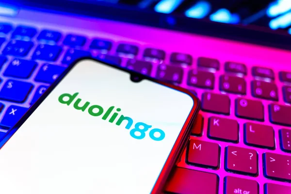 Prag, Çek Cumhuriyeti - 08 19 2025: Duolingo logosunu gösteren klavyenin üzerinde duran cep telefonunun yakından görüntüsü. Duolingo interaktif olarak dil öğrenmek için bir platformdur..