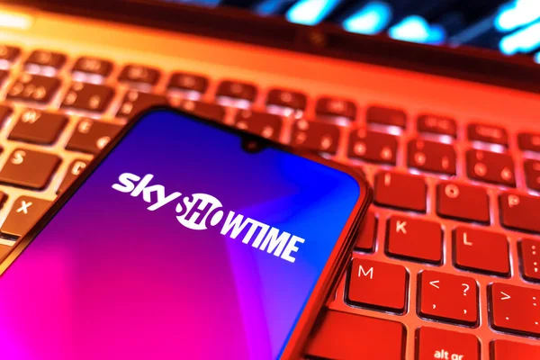 Prag, Çek Cumhuriyeti - 08 19 2025: SkyShowtime logosunu gösteren klavyenin üzerinde duran cep telefonunun yakından görüntüsü. SkyShowtime, sinema ve televizyon dizileri için bir yayın platformudur..