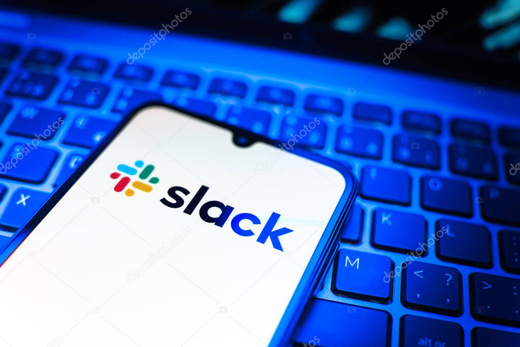 Prague, Czechia - 08 19 2025: A close-up view of a mobile phone lying on a keyboard, displaying Slack logo. Slack is a platform for team messaging and workplace communication.
