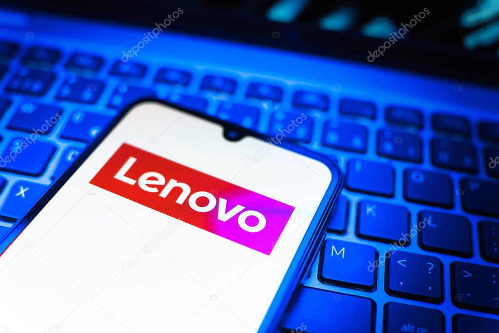 Prague, Czechia - 08 19 2025: A close-up view of a mobile phone lying on a keyboard, displaying Lenovo logo. Lenovo is a technology company producing computers and electronics.