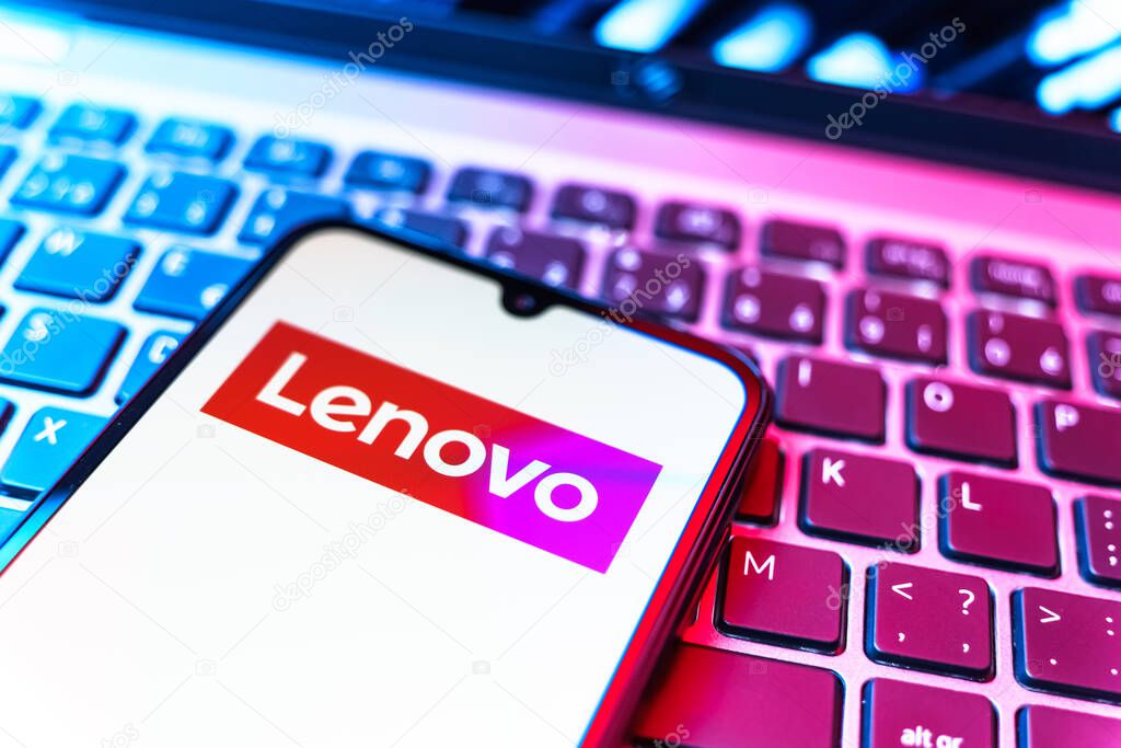 Prague, Czechia - 08 19 2025: A close-up view of a mobile phone lying on a keyboard, displaying Lenovo logo. Lenovo is a technology company producing computers and electronics.
