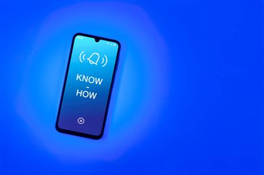 Sade arkaplandaki telefon çokbilmiş metni gösteriyor. Bilgi tecrübeyle kazanılır..