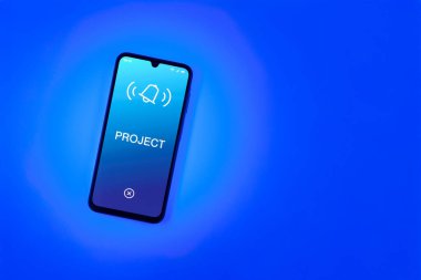 Sade arkaplandaki telefon Proje metnini gösteriyor. Proje, tanımlanmış hedefleri ve son teslim tarihleriyle planlandı.