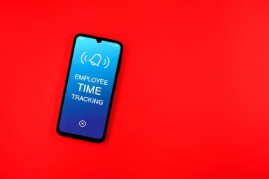 Sade arka plandaki telefon, Çalışan Zaman İzleme metnini gösteriyor. Çalışan Zaman İzleme, çalışanların çalışma saatlerini kaydediyor..