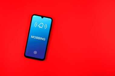 Sade arkaplandaki telefon Mobbing metnini gösteriyor. Gangsterlik iş arkadaşları arasında zorbalıktır..