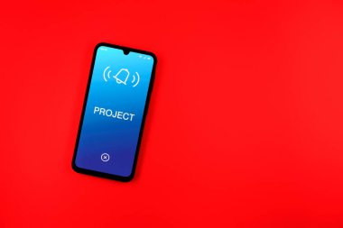 Sade arkaplandaki telefon Proje metnini gösteriyor. Proje, tanımlanmış hedefleri ve son teslim tarihleriyle planlandı.