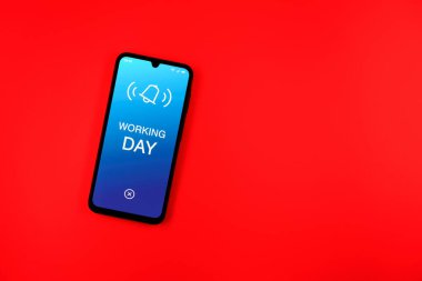Sade arkaplandaki telefon Çalışma Günü mesajını gösteriyor. Çalışma günü, çalışanlar için planlanmış bir gündür..