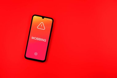 Sade arkaplandaki telefon Mobbing metnini gösteriyor. Gangsterlik iş arkadaşları arasında zorbalıktır..