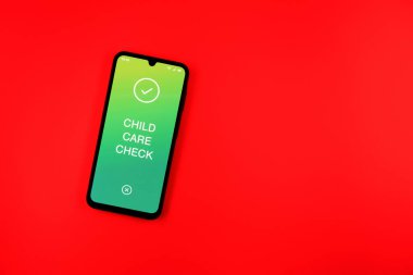 Sade arka plandaki telefon Çocuk Bakımı mesajını gösteriyor. Çocuk Esirgeme Kurumu, çocuk bakım giderleri olan çalışanlara verilen destektir..