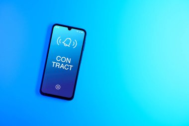 Sade arkaplandaki telefon sözleşmeli metni gösteriyor. Sözleşme, çalışma koşullarını belirleyen yasal bir anlaşmadır..