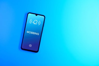 Sade arkaplandaki telefon Mobbing metnini gösteriyor. Gangsterlik iş arkadaşları arasında zorbalıktır..