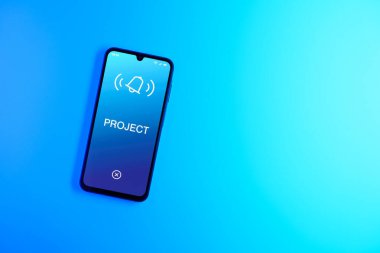 Sade arkaplandaki telefon Proje metnini gösteriyor. Proje, tanımlanmış hedefleri ve son teslim tarihleriyle planlandı.