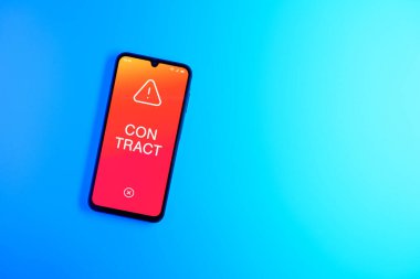Sade arkaplandaki telefon sözleşmeli metni gösteriyor. Sözleşme, çalışma koşullarını belirleyen yasal bir anlaşmadır..