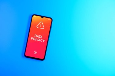 Sade arkaplandaki telefon Veri Gizliliği metnini gösteriyor. Veri Mahremiyeti kişisel ve hassas bilgilerin korunmasıdır.