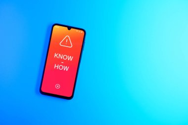Sade arkaplandaki telefon çokbilmiş metni gösteriyor. Bilgi tecrübeyle kazanılır..