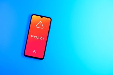 Sade arkaplandaki telefon Proje metnini gösteriyor. Proje, tanımlanmış hedefleri ve son teslim tarihleriyle planlandı.