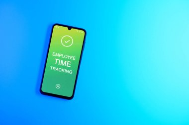Sade arka plandaki telefon, Çalışan Zaman İzleme metnini gösteriyor. Çalışan Zaman İzleme, çalışanların çalışma saatlerini kaydediyor..