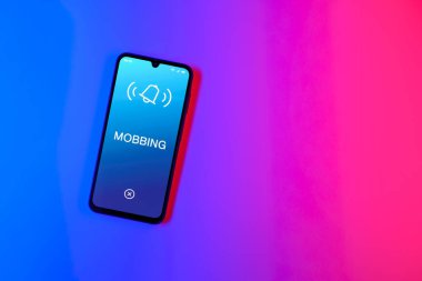 Sade arkaplandaki telefon Mobbing metnini gösteriyor. Gangsterlik iş arkadaşları arasında zorbalıktır..