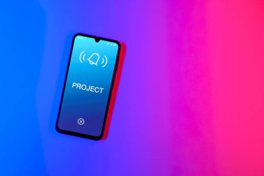 Sade arkaplandaki telefon Proje metnini gösteriyor. Proje, tanımlanmış hedefleri ve son teslim tarihleriyle planlandı.