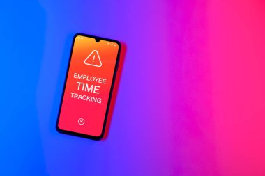 Sade arka plandaki telefon, Çalışan Zaman İzleme metnini gösteriyor. Çalışan Zaman İzleme, çalışanların çalışma saatlerini kaydediyor..