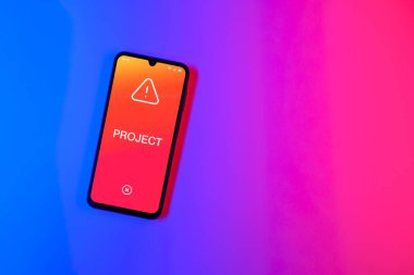 Sade arkaplandaki telefon Proje metnini gösteriyor. Proje, tanımlanmış hedefleri ve son teslim tarihleriyle planlandı.