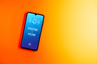 Sade arkaplandaki telefon çokbilmiş metni gösteriyor. Bilgi tecrübeyle kazanılır..