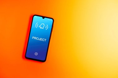 Sade arkaplandaki telefon Proje metnini gösteriyor. Proje, tanımlanmış hedefleri ve son teslim tarihleriyle planlandı.