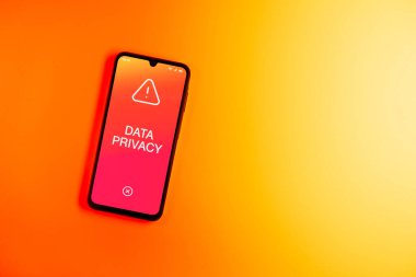 Sade arkaplandaki telefon Veri Gizliliği metnini gösteriyor. Veri Mahremiyeti kişisel ve hassas bilgilerin korunmasıdır.