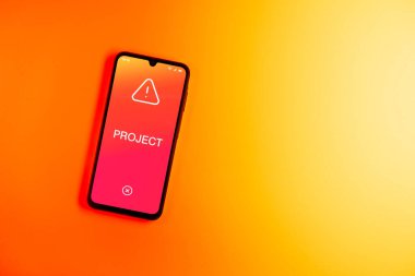 Sade arkaplandaki telefon Proje metnini gösteriyor. Proje, tanımlanmış hedefleri ve son teslim tarihleriyle planlandı.