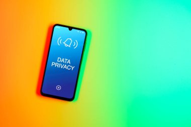 Sade arkaplandaki telefon Veri Gizliliği metnini gösteriyor. Veri Mahremiyeti kişisel ve hassas bilgilerin korunmasıdır.