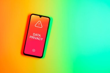 Sade arkaplandaki telefon Veri Gizliliği metnini gösteriyor. Veri Mahremiyeti kişisel ve hassas bilgilerin korunmasıdır.