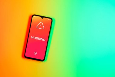 Sade arkaplandaki telefon Mobbing metnini gösteriyor. Gangsterlik iş arkadaşları arasında zorbalıktır..