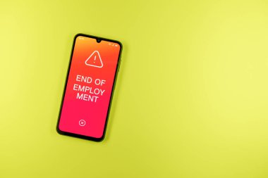 Sade arkaplandaki telefon İş Bulma metnini gösteriyor. İstihdamın Sonu, iş ilişkisinin sona ermesidir.