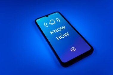 Üniformalı bir arka planda duran cep telefonunun metni ile ilgili bir detay. Bilgi tecrübeyle kazanılır..