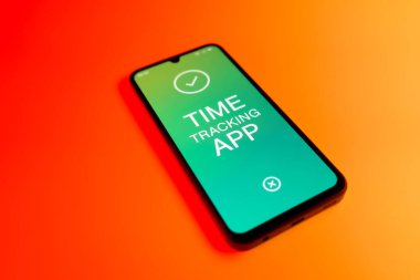 Üniformalı bir arka planda bulunan ve mesaj Zaman İzleme Uygulamasını gösteren bir cep telefonunun ayrıntısı. Zaman İzleme Uygulaması günlük kaydı çalışma saatleri için bir yazılımdır.