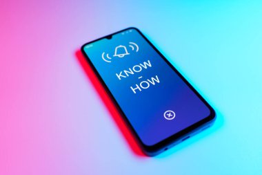 Üniformalı bir arka planda duran cep telefonunun metni ile ilgili bir detay. Bilgi tecrübeyle kazanılır..