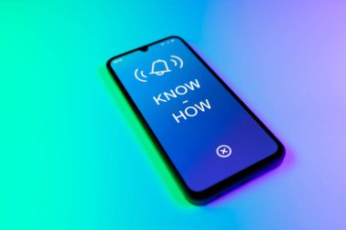 Üniformalı bir arka planda duran cep telefonunun metni ile ilgili bir detay. Bilgi tecrübeyle kazanılır..