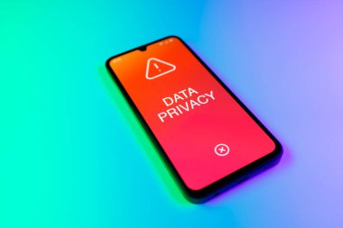 Üniformalı bir arka planda duran cep telefonunun bir ayrıntısı. Mesaj Veri Gizliliği 'ni gösteriyor. Veri Mahremiyeti kişisel ve hassas bilgilerin korunmasıdır.
