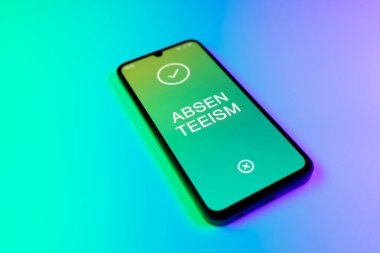 Üniformalı bir arkaplanda yatan cep telefonunun ayrıntıları eksik metni gösteriyor. Geçerli nedenler olmadan devamsızlık sık sık işten yoksunluktur.